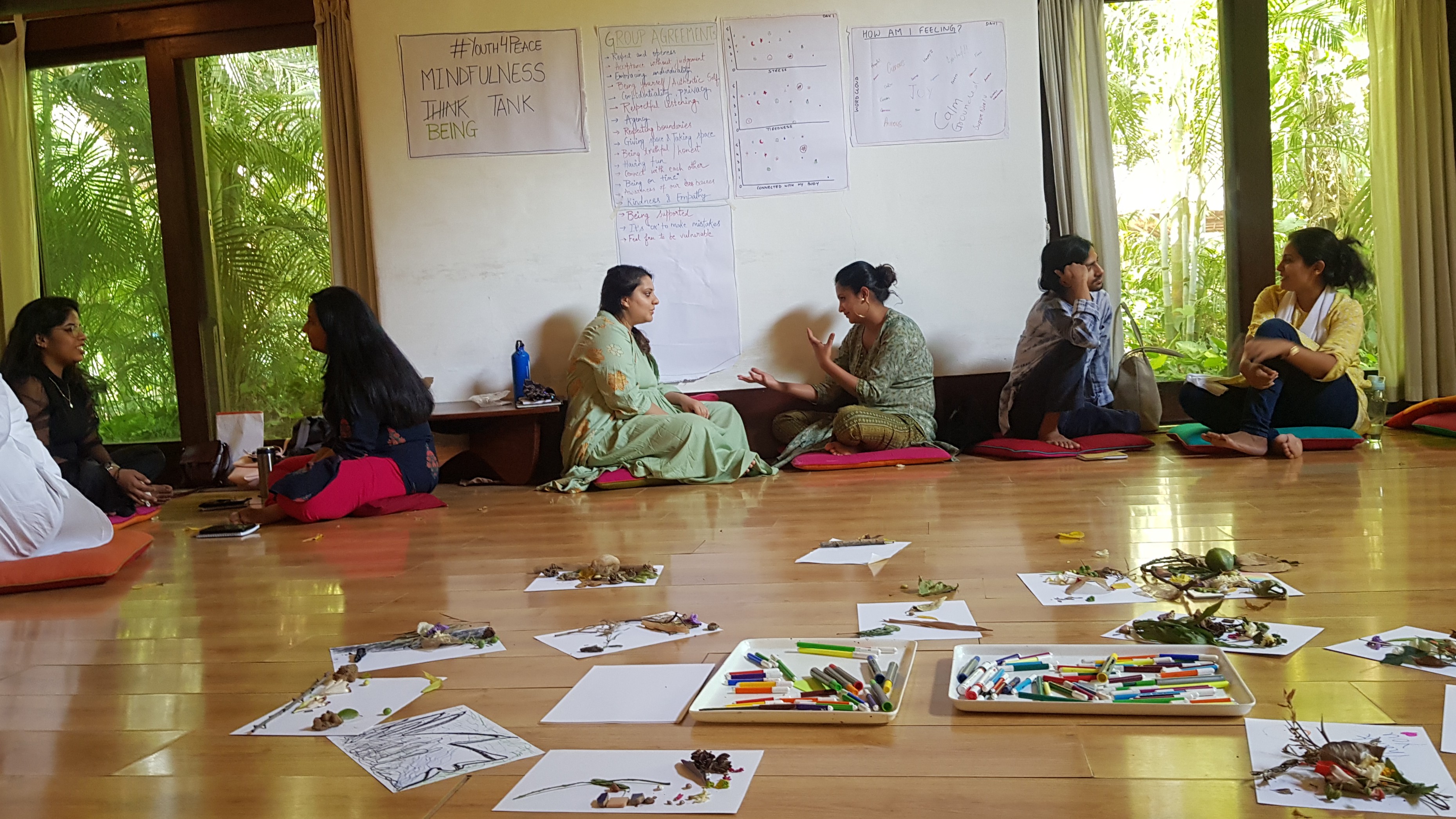 Group expressive arts therapy session — women in circle on wooden floor, Bangalore
